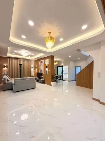 ห้องโถงชั้นล่างโล่ง พื้นกระเบื้องลายหินอ่อน เพดานไฟซ่อน และบันไดขึ้นชั้นสอง