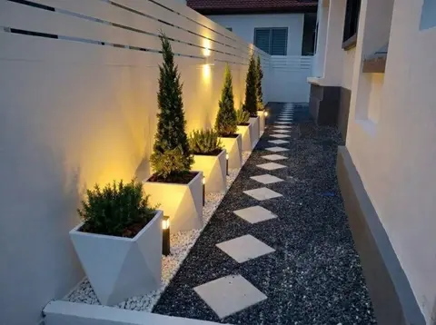 ทางเดินข้างบ้านโรยกรวด ปูแผ่นหิน และกระถางต้นไม้
